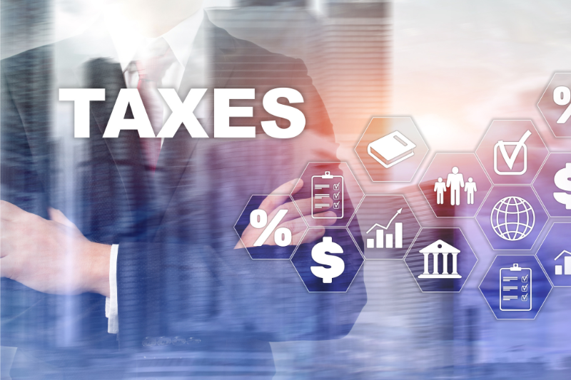 Taxes felirat, háttérben egy öltönyös férfi.