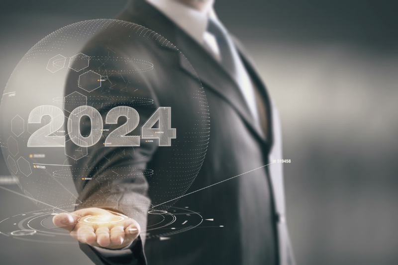 2024 kivetülése egy öltönyös ember keze fölött.